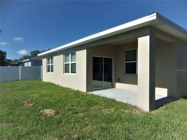 back of house featuring a yard and a patio