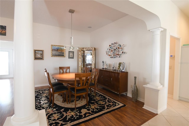 dining space with light wood-type flooring and decorative columns