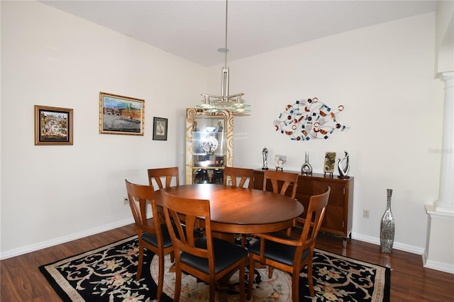 dining room featuring dark wood-type flooring and decorative columns