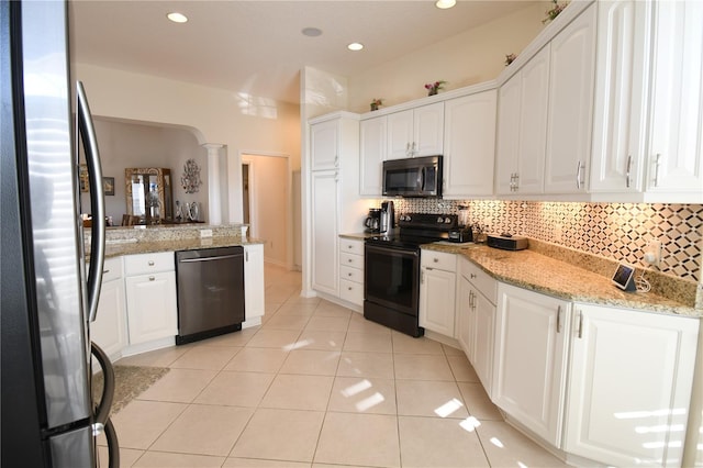 kitchen with appliances with stainless steel finishes, backsplash, light stone counters, light tile patterned floors, and white cabinets