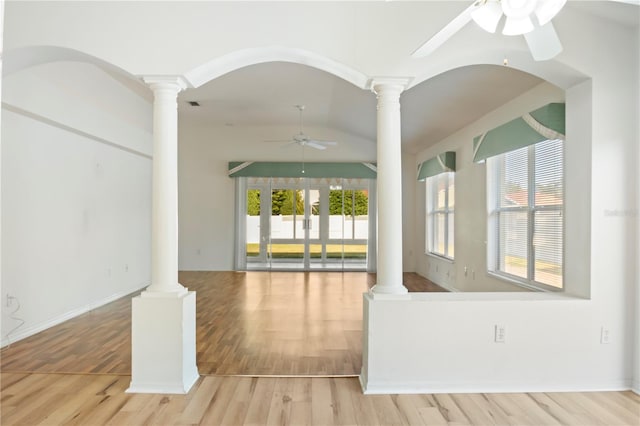 unfurnished living room with light hardwood / wood-style floors, ornate columns, and lofted ceiling