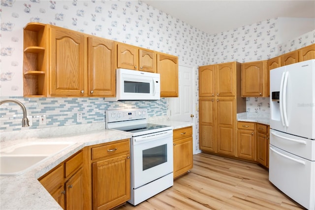 kitchen with decorative backsplash, sink, light hardwood / wood-style floors, and white appliances