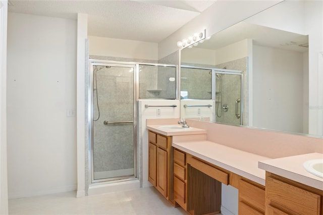 bathroom featuring a textured ceiling, vanity, and walk in shower