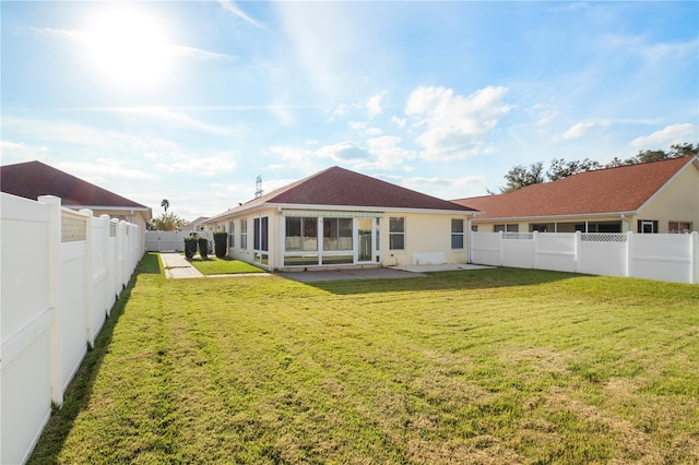 back of house featuring a lawn and a patio