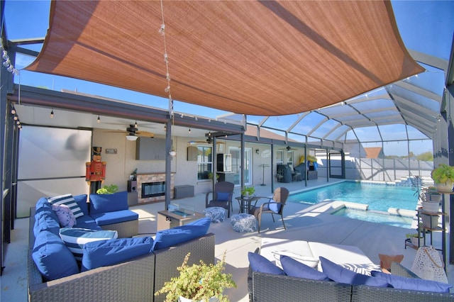 view of patio with an outdoor living space with a fireplace, a pool with hot tub, ceiling fan, and glass enclosure