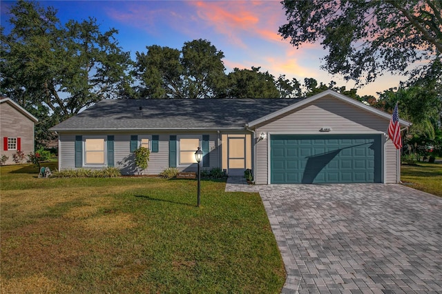 ranch-style house with a yard and a garage