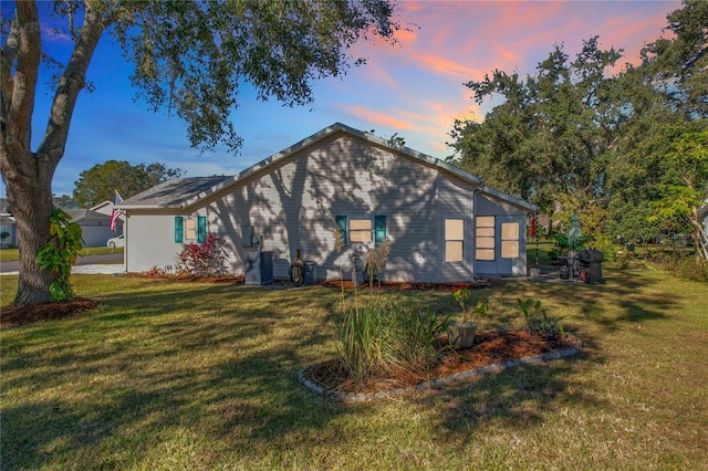 property exterior at dusk with a yard