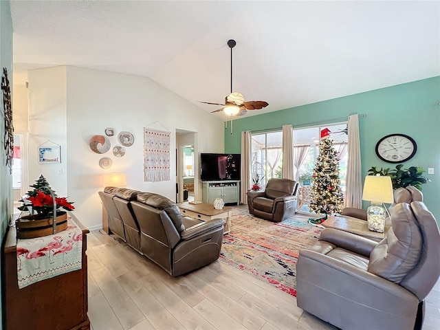 living room with ceiling fan, light hardwood / wood-style floors, and vaulted ceiling