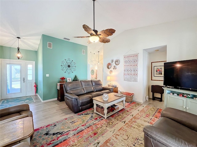 living room with ceiling fan, light hardwood / wood-style floors, and vaulted ceiling