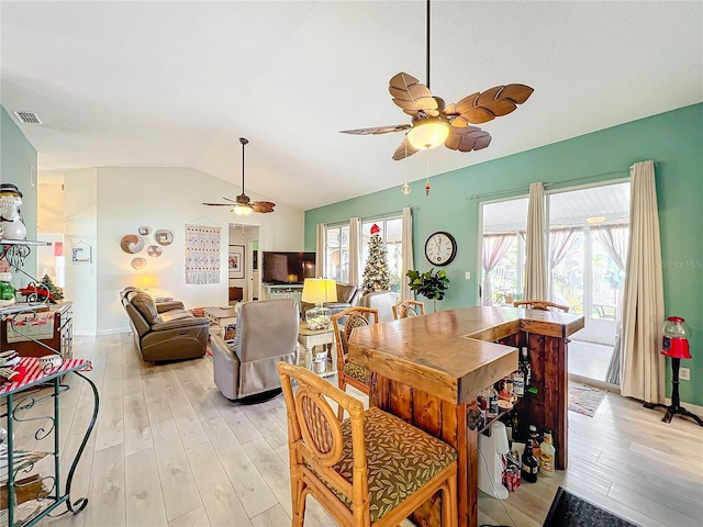 dining space with light hardwood / wood-style flooring and vaulted ceiling