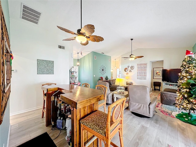 dining room with light hardwood / wood-style floors and lofted ceiling