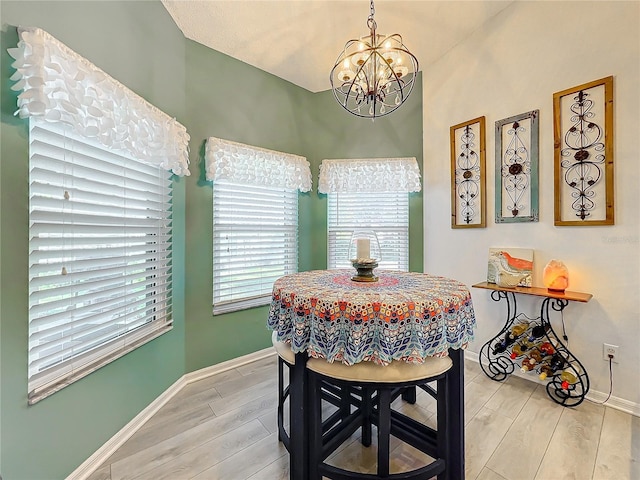 dining space with a notable chandelier and light hardwood / wood-style flooring