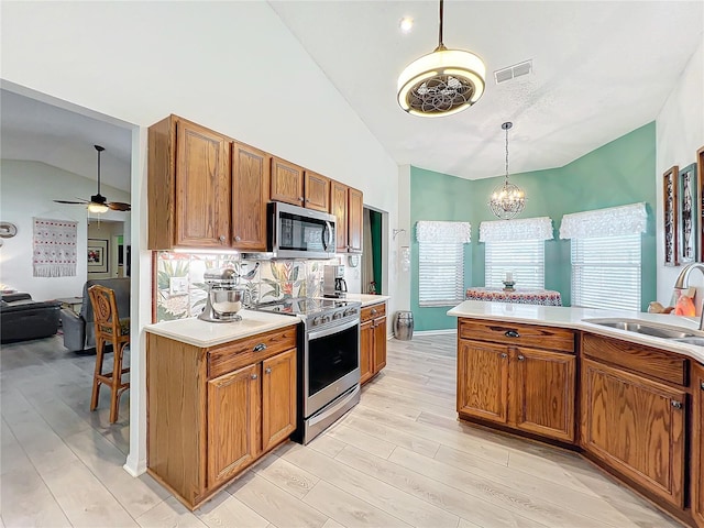 kitchen featuring sink, light wood-type flooring, stainless steel appliances, and vaulted ceiling