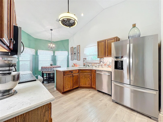 kitchen with stainless steel appliances, light hardwood / wood-style flooring, kitchen peninsula, lofted ceiling, and decorative backsplash