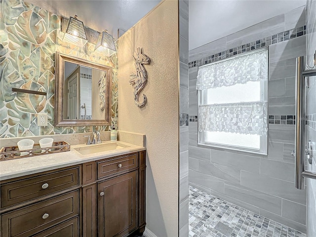 bathroom with vanity and a tile shower