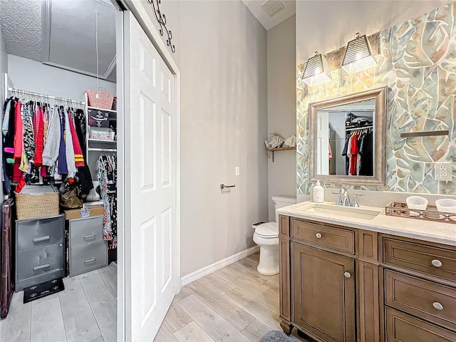 bathroom with vanity, toilet, and wood-type flooring