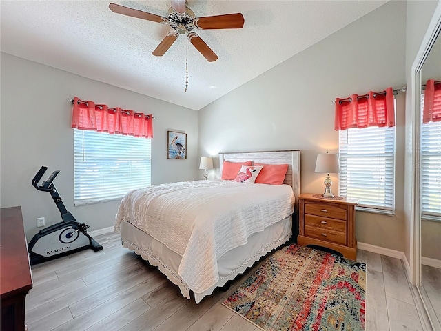 bedroom with ceiling fan, a textured ceiling, and light hardwood / wood-style flooring