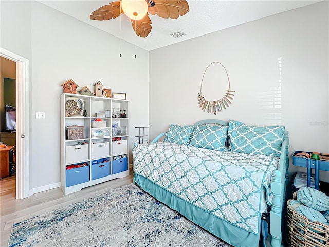 bedroom featuring ceiling fan, wood-type flooring, and a textured ceiling