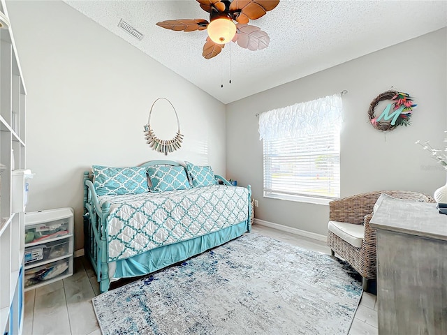 bedroom featuring light wood-type flooring, a textured ceiling, ceiling fan, and lofted ceiling