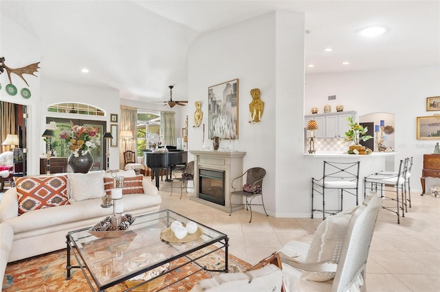 living room featuring light tile patterned floors, vaulted ceiling, and ceiling fan