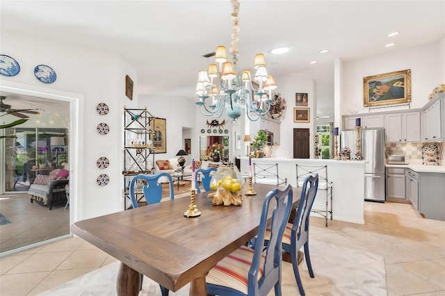 dining area with ceiling fan with notable chandelier and light tile patterned floors