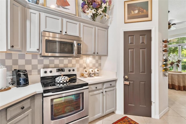 kitchen featuring decorative backsplash, appliances with stainless steel finishes, and light tile patterned floors