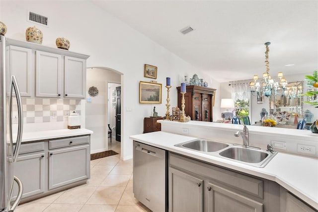 kitchen with gray cabinetry, sink, stainless steel appliances, decorative light fixtures, and light tile patterned floors