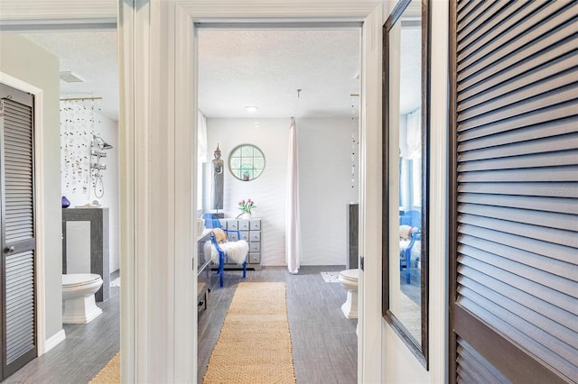 hallway featuring wood-type flooring and a textured ceiling