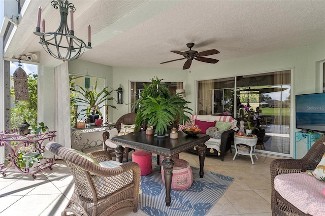 sunroom featuring ceiling fan with notable chandelier