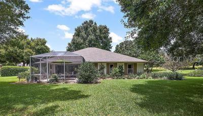 rear view of house featuring a lanai and a lawn