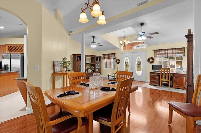 dining room with french doors, light hardwood / wood-style floors, vaulted ceiling, and an inviting chandelier