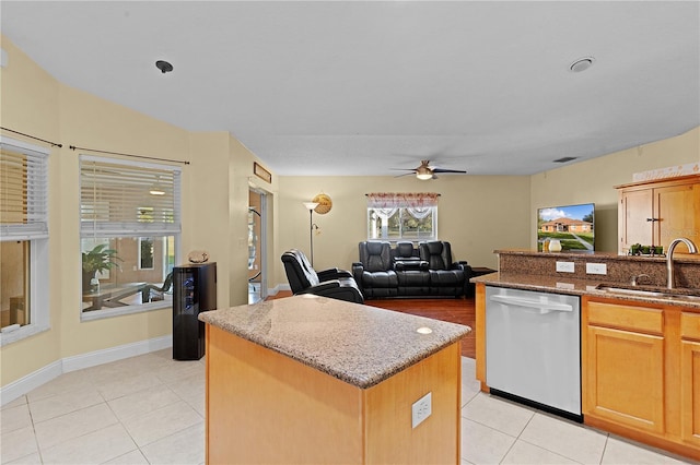 kitchen featuring ceiling fan, dishwasher, a center island, sink, and light tile patterned floors