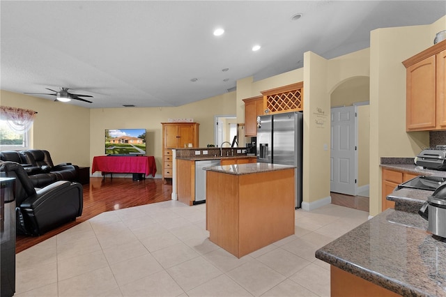 kitchen with ceiling fan, light tile patterned floors, appliances with stainless steel finishes, a kitchen island, and kitchen peninsula