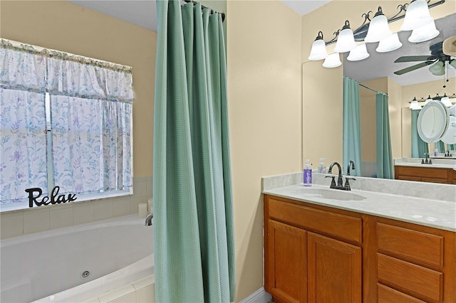 bathroom with ceiling fan, vanity, and a relaxing tiled tub