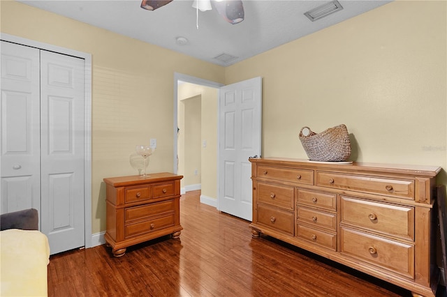 bedroom with ceiling fan, dark hardwood / wood-style flooring, and a closet