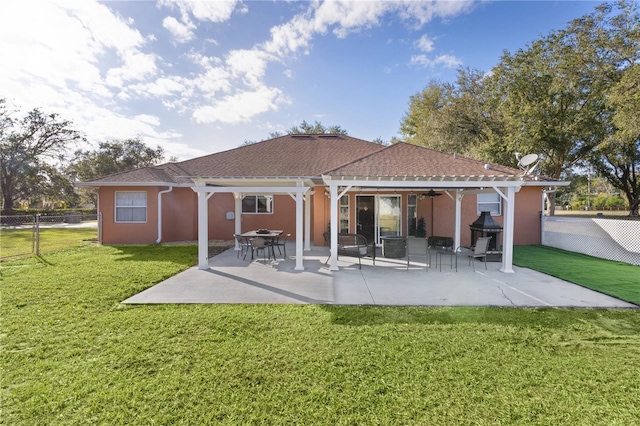 back of property with a patio, ceiling fan, and a lawn