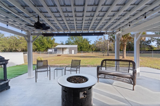 view of patio with ceiling fan and an outdoor fire pit