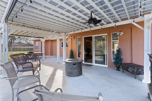 view of patio featuring ceiling fan and a fire pit