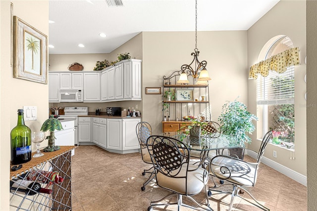 tiled dining area featuring an inviting chandelier