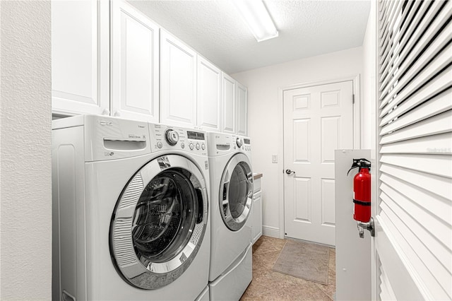 laundry room featuring washer and dryer, cabinets, light tile patterned floors, and a textured ceiling