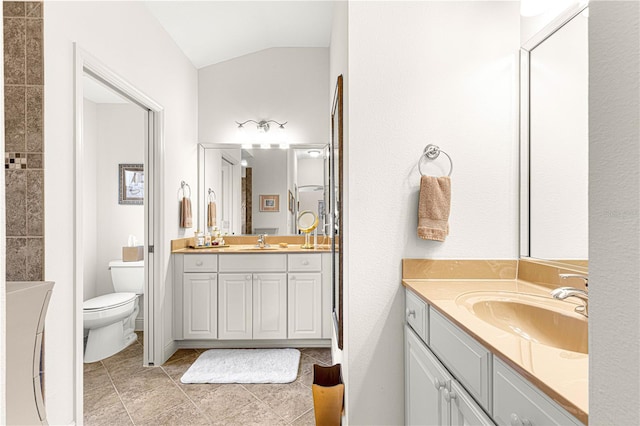 bathroom with tile patterned floors, vanity, toilet, and vaulted ceiling