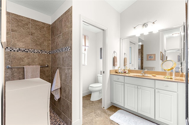 bathroom with tile patterned floors, vanity, toilet, and a textured ceiling