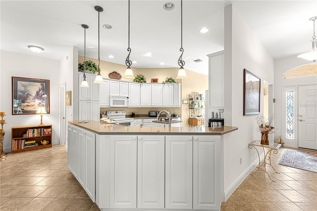 kitchen featuring white cabinetry, pendant lighting, vaulted ceiling, white appliances, and light tile patterned floors