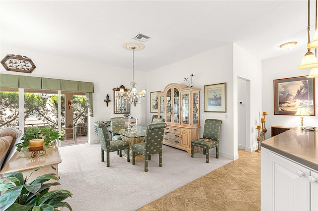 dining area with light carpet and a chandelier