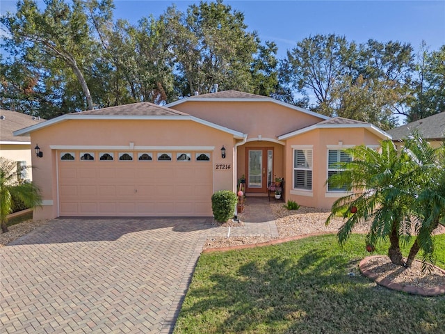 ranch-style home with a front lawn and a garage