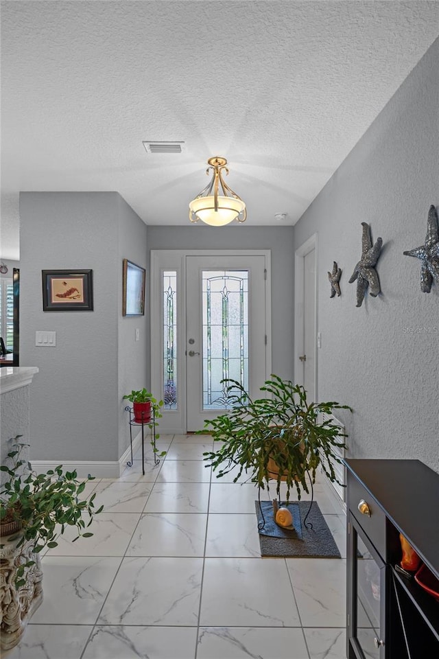 entryway with a textured ceiling