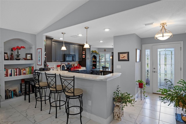 kitchen with stainless steel electric range, lofted ceiling, a kitchen breakfast bar, decorative light fixtures, and kitchen peninsula