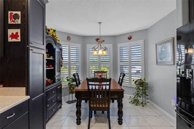 dining space with a textured ceiling, an inviting chandelier, and a healthy amount of sunlight