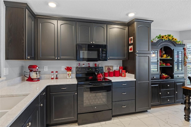 kitchen with sink, black appliances, and a textured ceiling