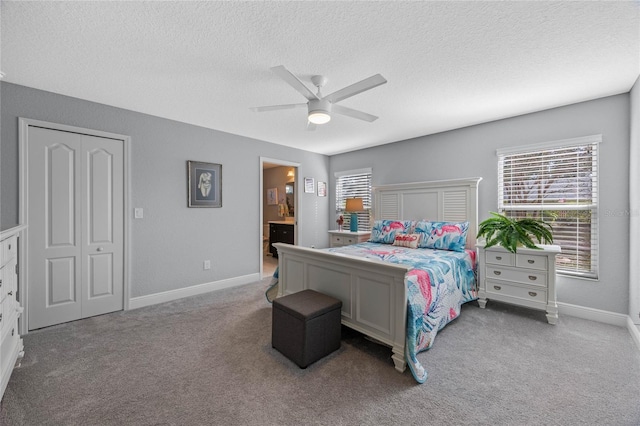 carpeted bedroom with a textured ceiling, ceiling fan, ensuite bathroom, and a closet